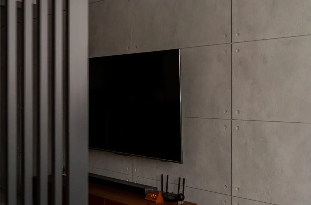 Brutalist space featuring concrete panels and wood furniture.