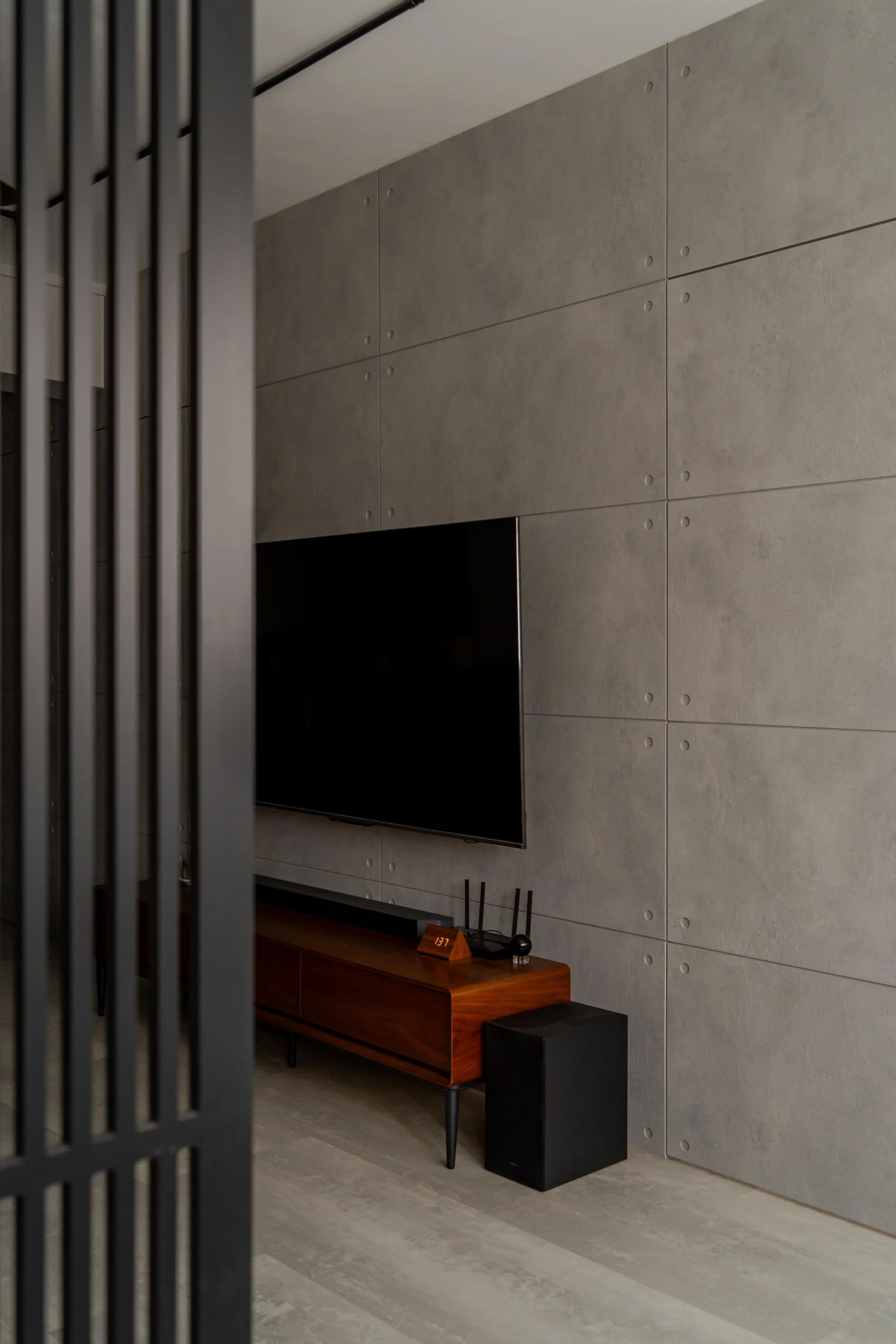 Brutalist space featuring concrete panels and wood furniture.